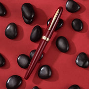 HONGDIAN 1841 Red Fountain Pen with Closed Cap with Red background and Pen Support on Black Stones
