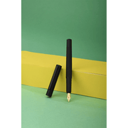 HONGDIAN H2 Black Fountain Pen Open Cap Display and Cap Beside Pen with Support of Yellow Paper Box and Light Green Background
